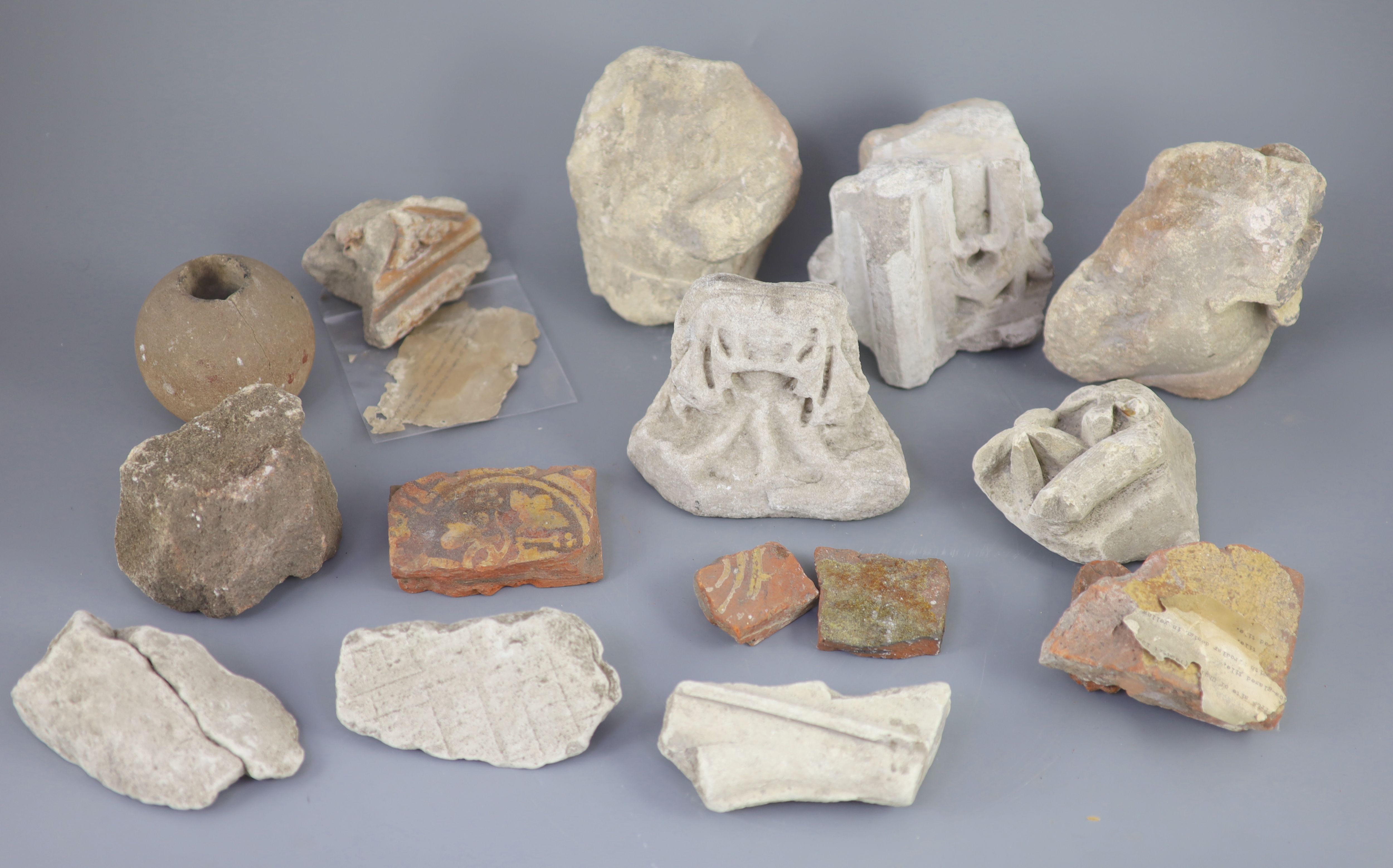 A group of English medieval church/priory architectural stonework and tile fragments, some pieces with inscribed labels of provenance,
